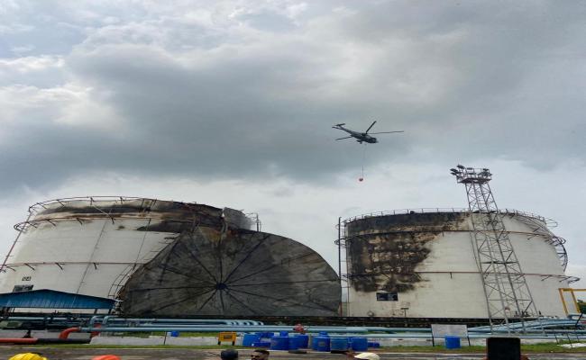 भारतीय नौसेना का सीकिंग हेलीकॉप्टर आग बुझाने के लिए फायर बकेट के साथ तैनात